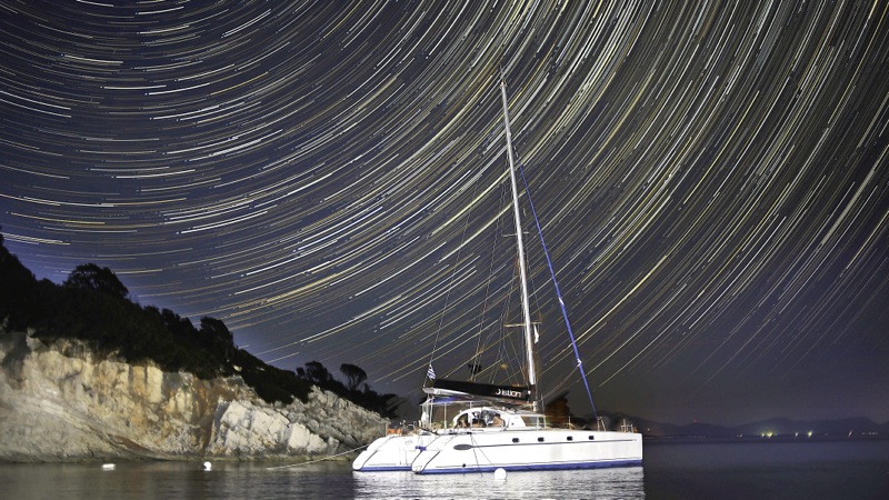 Naturist Sailing Stars above Catamaran in Greece
